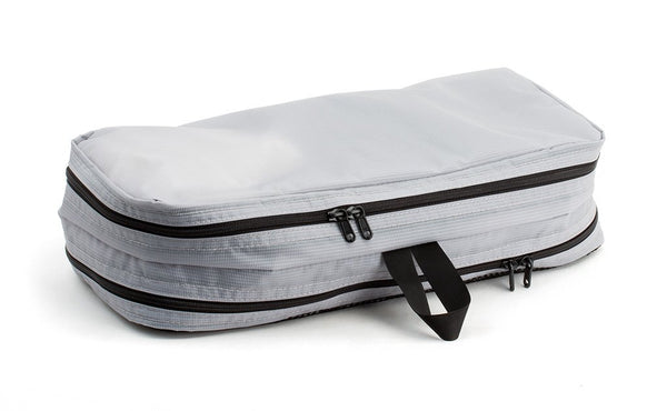 A filled and zipped closed Northwest Sky (light grey) Aether Small Aeronaut 45 Packing Cube all-fabric side up.